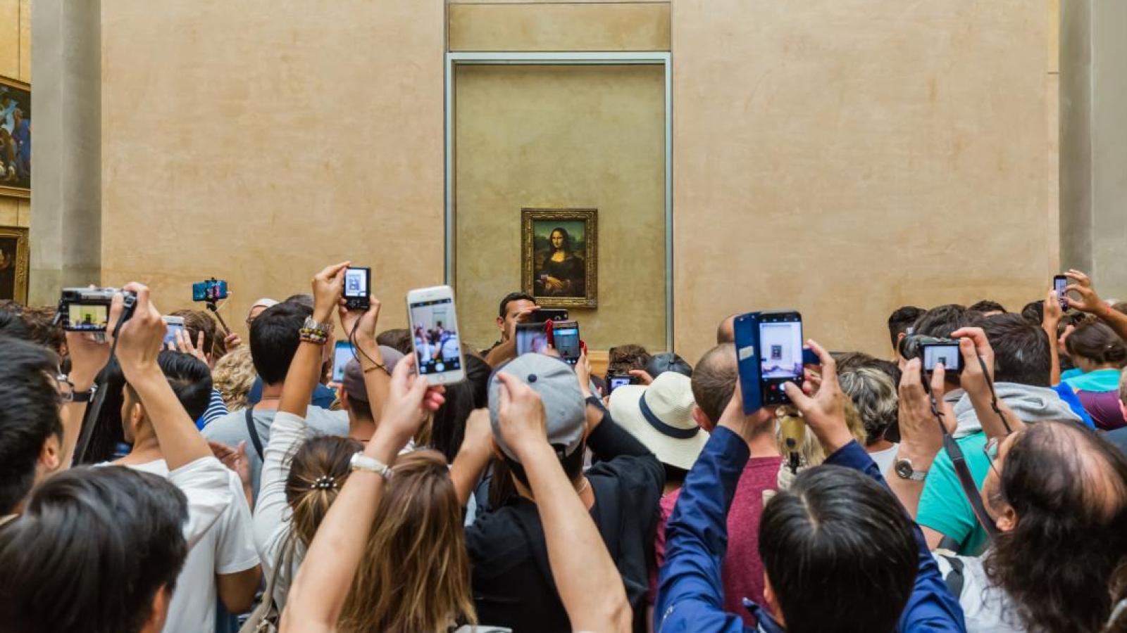 Los turistas fotografiando el cuadro de la Mona Lisa, en París/dreamstime