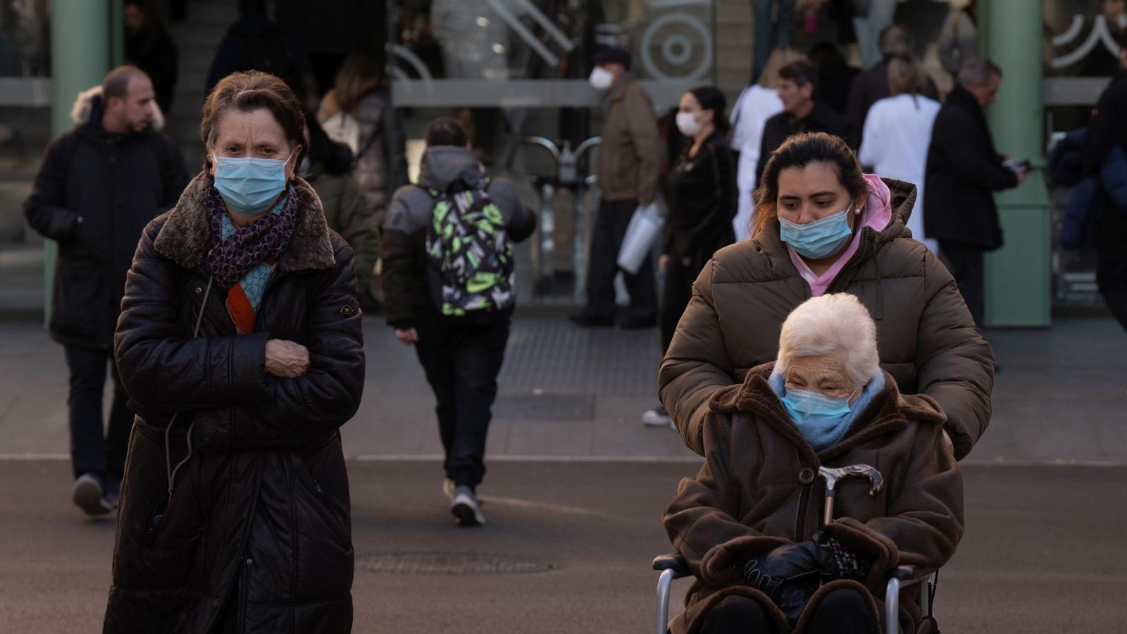 Varias personas con mascarilla a la salida de un hospital 