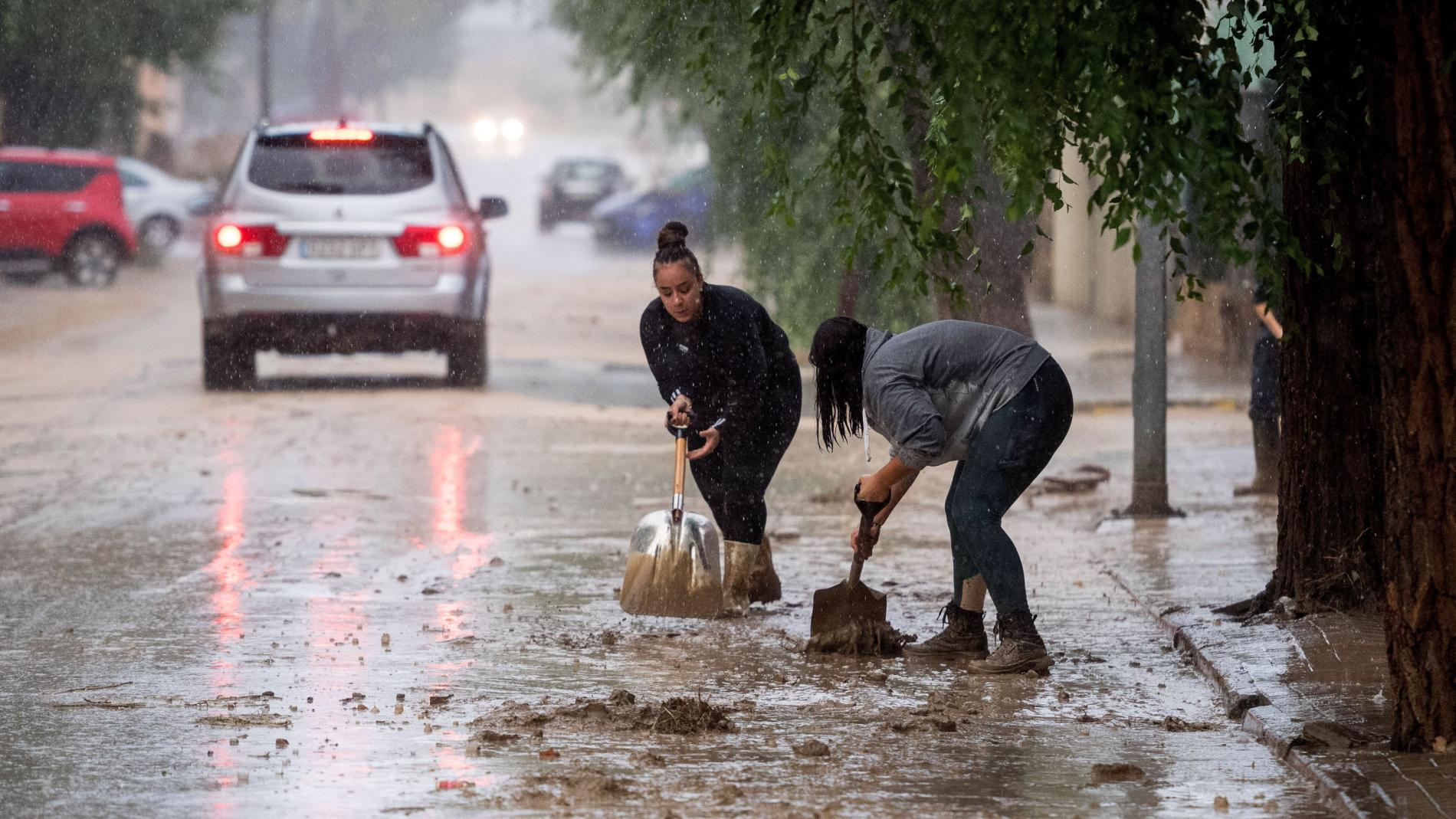 Varias personas retiran el lodo acumulado en Magán (Toledo) a causa de las fuertes lluvias 