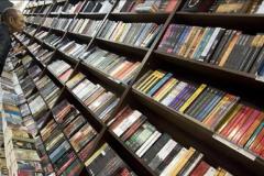 Un hombre ojea varios libros en una librería