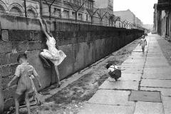 Tres niños juegan en el muro de Berlín