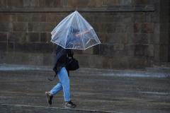 Una persona caminado bajo lluvia y fuerte viento en Toledo