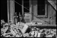 Fotografía de dos mujeres que observan los efectos de un bombardeo en el barrio de la Barceloneta de Barcelona, en 1937