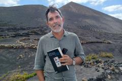 El autor posa con la novela en Lanzarote, donde transcurre la trama principal de la misma