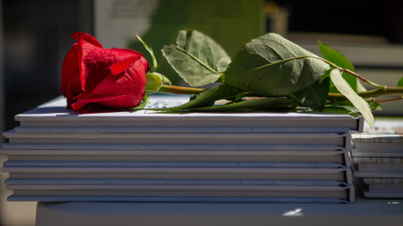 Detalle de una rosa sobre los libros de una de las paradas de las Ramblas de Barcelona este viernes, cuando Cataluña celebra una esperada "diada" de Sant Jordi que por primera vez desde hace 2 años tendrá puntos de venta de libros y rosas en las calles. EFE/Enric Fontcuberta