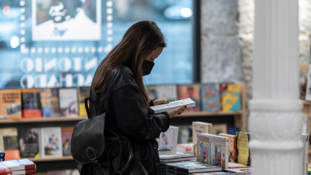 Una joven ojea un libro en la Librería Antonio Machado de Madrid