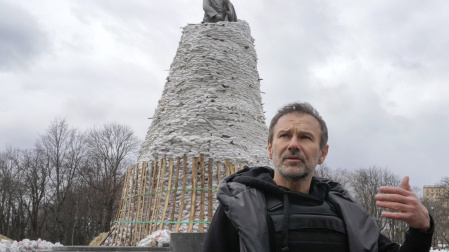 El músico ucraniano Svyatoslav Vakarchuk gesticula contra el fondo de un monumento de Taras Shevchenko, un famoso poeta ucraniano y símbolo nacional, cubierto con bolsas para protegerlo del bombardeo ruso en Járkov