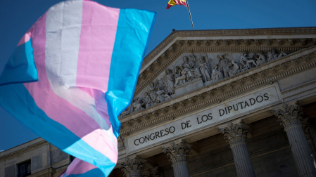 Una bandera del colectivo transexual ondea a las puertas del Congreso, en Madrid