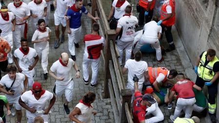 PAMPLONA, 11/07/2022.- Varios mozos son atendidos por miembros de la Cruz Roja durante el quinto encierro de los Sanfermines que ha resultado muy peligroso y accidentado, en el que los astados han arremetido en varios momentos contra los mozos, en una carrera de 3 minutos y 12 segundos de duración. EFE/Jesús Diges