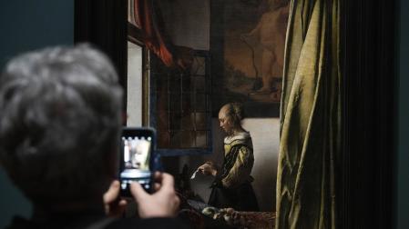 Una visitante contempla uno de los óleos del pintor