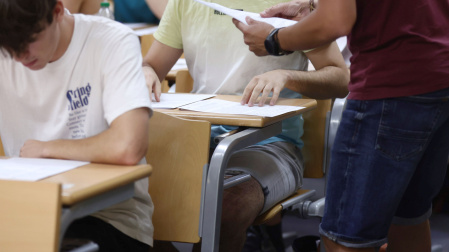 Un profesor reparte los exámenes de la EVAU