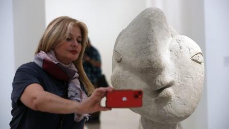 Una visitante se hace un "selfie" junto a una "Cabeza de mujer" (1937) de cemento propiedad del Museo Picasso de Antibes