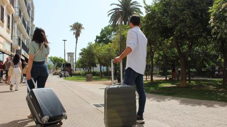 Dos turistas con sus maletas por el centro de Málaga, la ciudad que concentra la mayor oferta de pisos turísticos de Andalucía