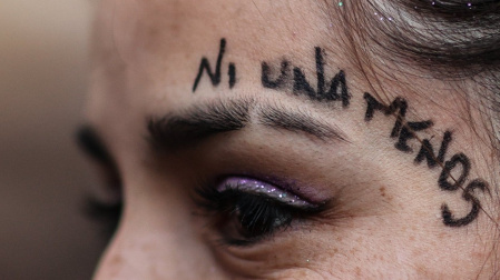 Una mujer participa con miles de mujeres en una marcha bajo la consigna "ni una menos".