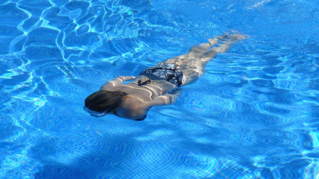 Una chica nada en una piscina