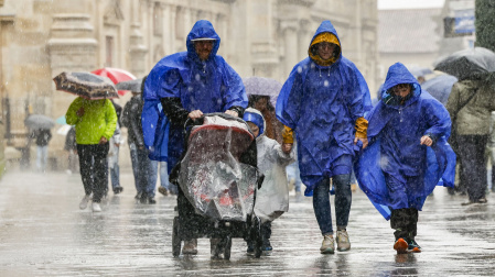 Turistas bajo la lluvia esta mañana en Santiago de Compostela