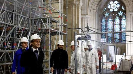 French President Emmanuel Macron (2L) walks inside the nave during a visit of the reconstruction work at the Notre-Dame de Paris Cathedral, on the Ile de la Cite in Paris.