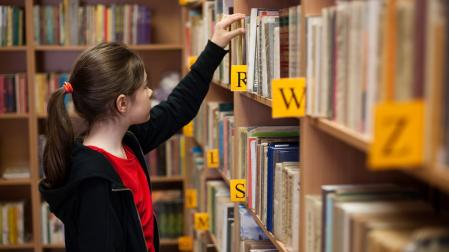 Estudiante consulta una biblioteca