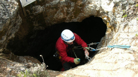 Un varón practicando espeleología en la cueva Sima del Fraile en Cifuentes (Guadalajara) 