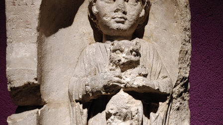 Lápida funeraria romana de una niña que sostiene a un cachorro en el Museo de Aquitania de Burdeos