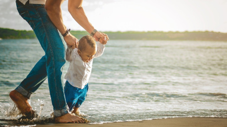 Primeros pasos de un niño en la playa