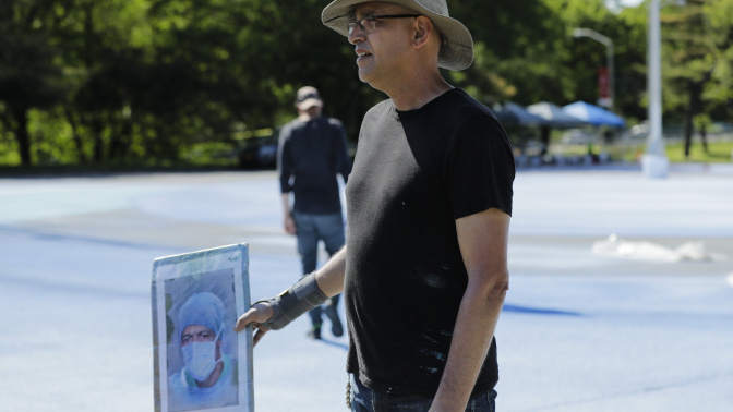 Rodríguez Gerada sostiene en su mano el retrato que le ha servido de guía para levantar un inmenso homenaje a la víctimas dela COVID-19