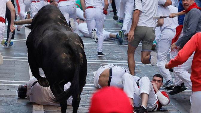 Varios mozos caen ante un toro rezagado de la ganadería gaditana de Fuente Ymbro. EFE/Villar López