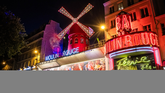 Open air French Can Can performance at the Moulin Rouge to celebrate the return of its windmill blades