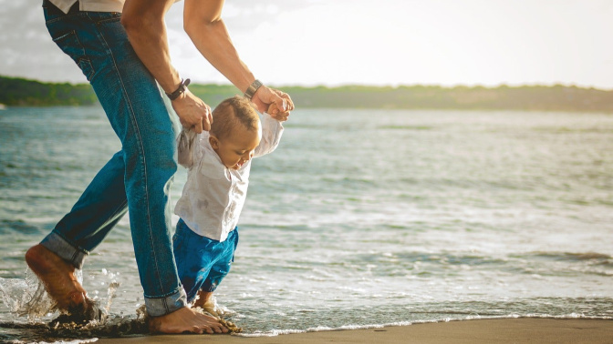 Primeros pasos de un niño en la playa